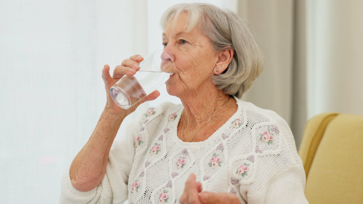 woman swallowing pills